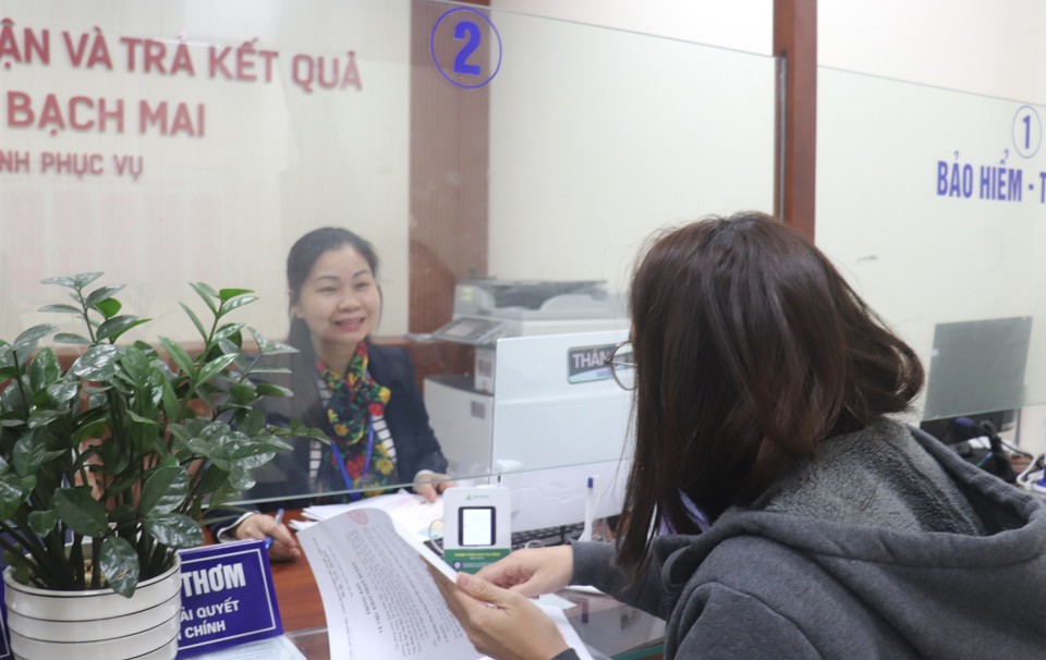 Según el ex viceministro del Interior Nguyen Tien Dinh, no organizarse a nivel de distrito en este momento está en total sintonía con la tendencia actual (foto: funcionarios del Comité Popular del Barrio Bach Mai, Distrito Hai Ba Trung, orientando a la gente para realizar los procedimientos administrativos)